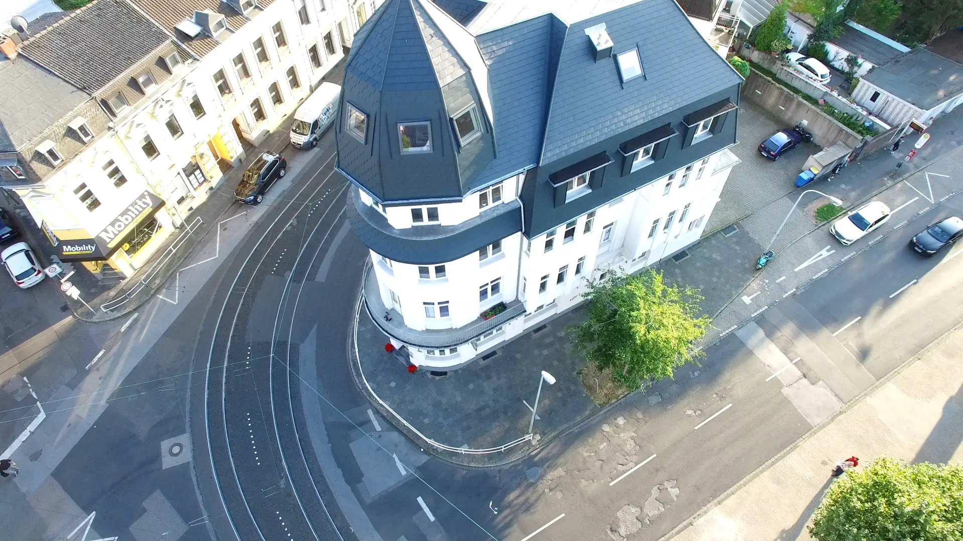 Luftaufnahme eines Eckhauses mit Turm und neu eingedecktem Schieferdach